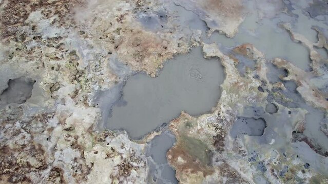Aerial view tilt up over Hverir geothermal area with boiling water in Iceland