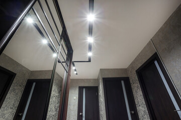 suspended ceiling with halogen spots lamps and drywall construction in empty room in apartment or...