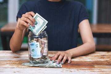 Person saving money on jar