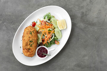 chicken cordon bleu with salad and cranberry sauce