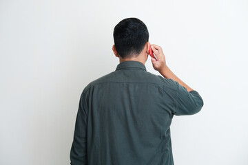 Back view of a man answering mobile phone call