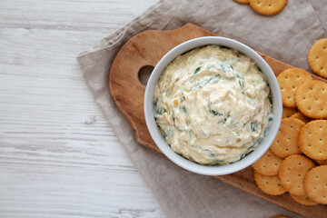 Homemade Caramelized Onion and Spinach Dip with Salty Round Crackers, top view. Flat lay, overhead, from above. Copy space.