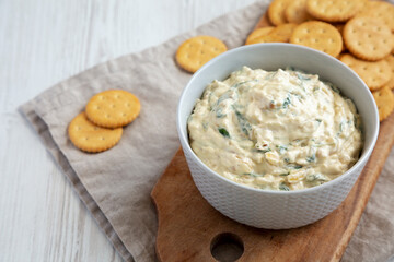 Homemade Caramelized Onion and Spinach Dip with Salty Round Crackers, side view.