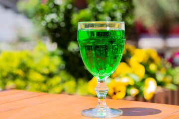 close-up Green lemonade Tarragon in a glass glass on a blurry background. Green drink from healthy herbs Tarragon