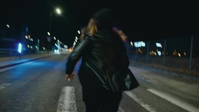 Hooded woman chased down empty street at night, camera shake