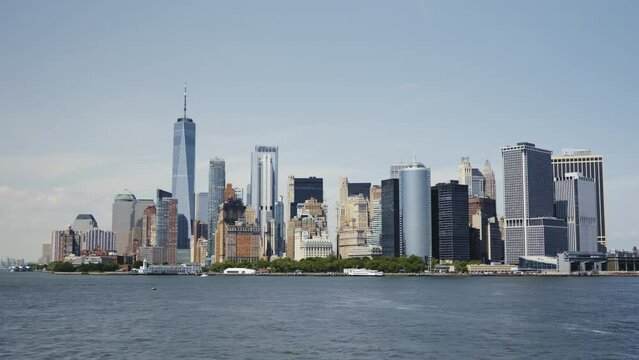 The Financial District of Manhattan, with the One World Trade Center on a sunny day with blue skies, moving shot.
