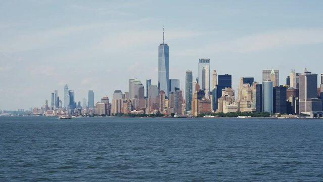 Wide angle shot of the Financial District of Manhattan, with the One World Trade Center on a sunny day with blue skies, moving shot.
