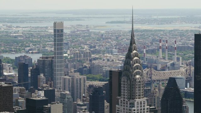 The Chrysler Building of Manhattan with the Ed Koch Queensboro Bridge in the background on a sunny day, static shot.
