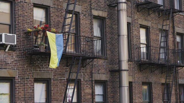 The Ukrainian flag waving in the wind for solidarity on a house in Manhattan, static shot.