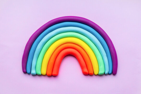 Colorful rainbow of plasticine on pink background. Made from plasticine. Isolate