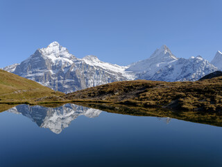 Fototapeta na wymiar Rocky mountains and reflection on the surface of the lake. Landscape in Grindelwald, Switzerland.