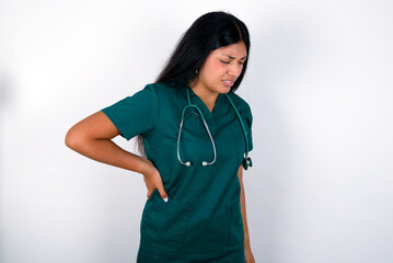 Doctor hispanic woman wearing surgeon uniform over white wall Suffering of backache, touching back with hand, muscular pain