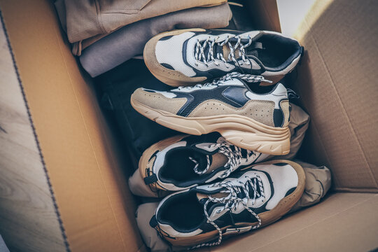 Men's sneakers and clothes in a box, shopping unpacking
