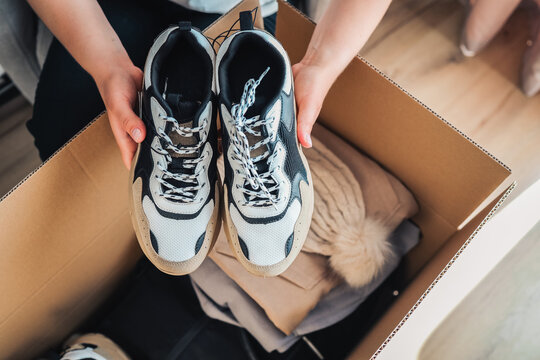 Men's sneakers and clothes in a box, shopping unpacking