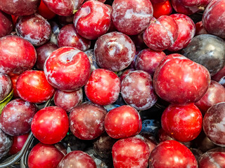 Large plums on the counter of the city market. Natural background
