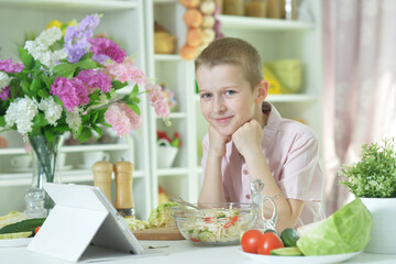 Cute little boy preparing salad