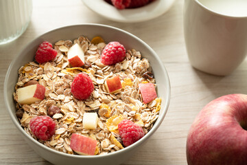 Schale mit Müsli und frischen Himbeeren und Apfel