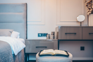 Open bible on table in bedroom, modern interior