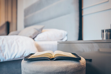 Open bible on table in bedroom, modern interior