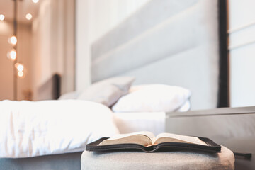 Fototapeta na wymiar Open bible on table in bedroom, modern interior