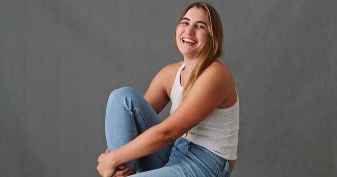  Close up of a laughing smiling Caucasian woman sitting on a stool 
