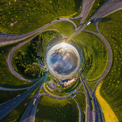 blue sphere of sky with clouds overlooking old town, urban development, historic buildings, crossroads and road junction. Transformation of spherical 360 panorama in abstract aerial view.