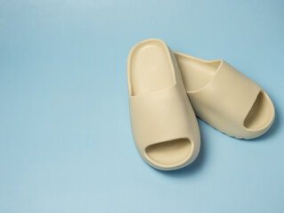 A pair of slides with an open toe pillow isolated on a colored background. Soft slippers