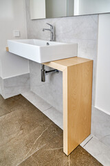 Modern ceramic sink with faucet installed on wooden console table in bathroom. Sanitary engineering...