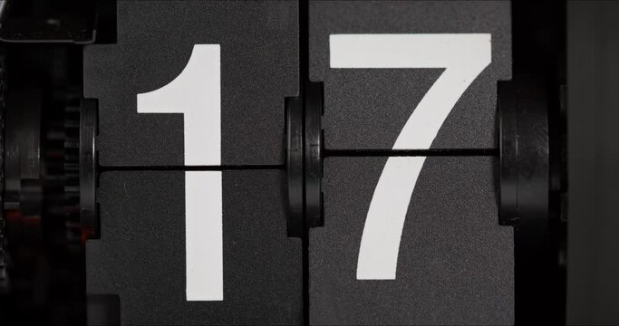 Flip clock turns slowly from day 16 to 17 on black background, Time concept.