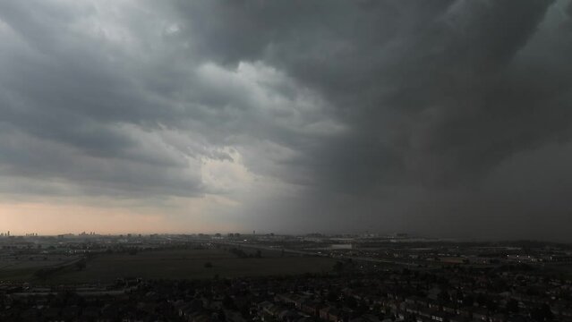 Time lapse storm clouds swirling above Toronto highway covering landscape in heavy dark rainfall
