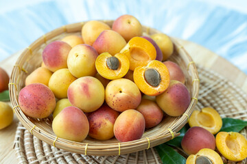 Apricot fruit with leaf on bamboo mat background, Fresh Apricot on wooden plate over wooden Background.