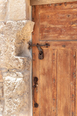 Decorative  massive wooden door with a metal bolt and a metal padlock to a residential building in the Arab Christian village Miilya, in the Galilee, in northern Israel