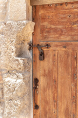 Decorative  massive wooden door with a metal bolt and a metal padlock to a residential building in the Arab Christian village Miilya, in the Galilee, in northern Israel