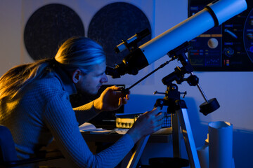 Astronomer man looks through telescope at the night sky, space, cosmos, universe, Milky way. Male...