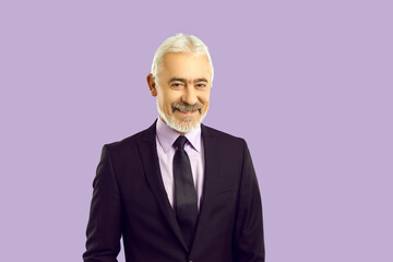 Headshot portrait of mature grey-haired bearded businessman in suit isolated on purple studio...