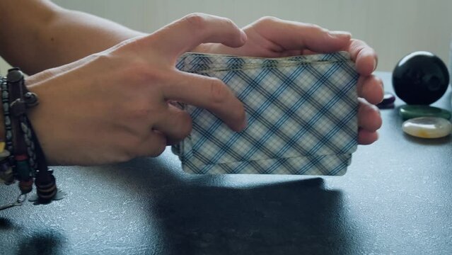 women's hands shuffle a deck of tarot cards