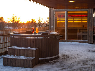 Hot outdoor wooden bath tub on terrace of private house. Finnish sauna
