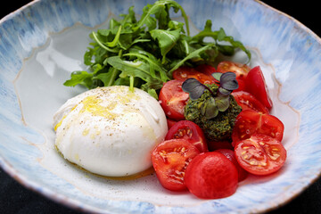 Burrata with arugula, cherry tomatoes and pesto sauce