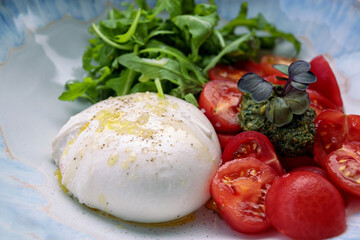 Burrata with arugula, cherry tomatoes and pesto sauce