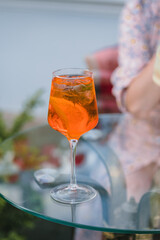 Glass of an aperol cocktail on a table outdoors. Summer refreshing drinks.