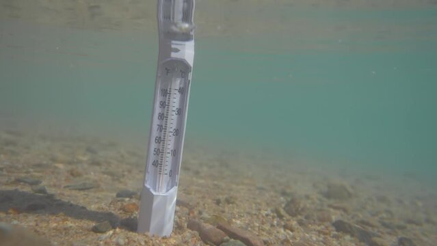 climate change and global warming concept. thermometer in water, increasing temperature in ocean.