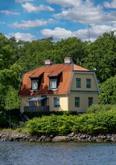 Summertime view of houses on islands in the archipelago outside of Stockholm, the capital of Sweden, one of the Nordic countries along the Baltic Sea in Scandinavia, Europe.  - 516539955