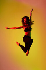 Modern dancer jumping high in neon light . Background. Concept of emotions, facial expression, sales, advertising. Jumping high, flying, dancing.