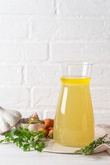 Chicken stock broth in a glass jug