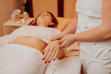 Fototapeta na wymiar Beautician massaging hand of female in the spa salon, lifestyle and healthcare concept