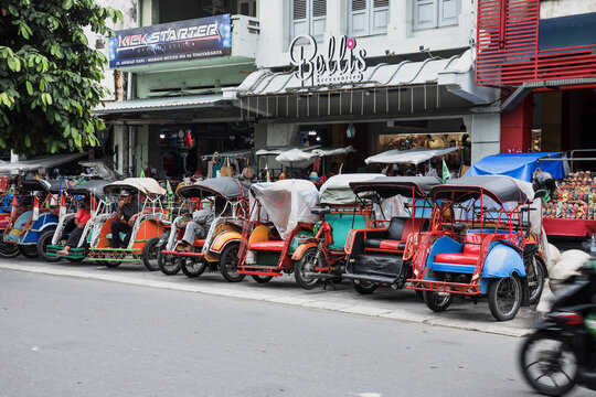 Yogyakarta, Indonesia - May 2022: Becak parked on the road side of Malioboro Street. Becak is a local rickshaw or pedicab, traditional transportation from Indonesia.