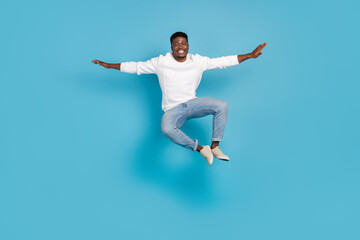 Fototapeta na wymiar Full length portrait of satisfied cheerful person arms flight toothy smile rejoice isolated on blue color background