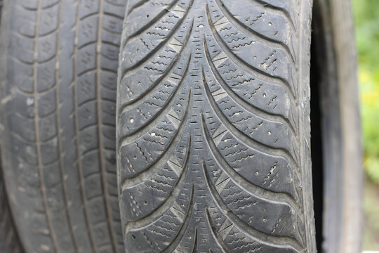 Old winter and summer tires with varying degrees of wear
