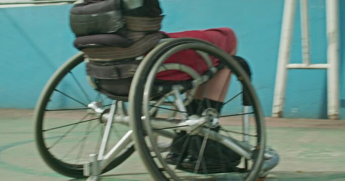 One disabled basketball player playing ball outside. Closeup of paraplegic person on wheelchair action motion. Sport and disability concept