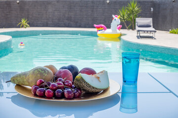 Fototapeta na wymiar fresh fruit tray covered with mesh for insects, waiting by the pool, fruit in the pool...